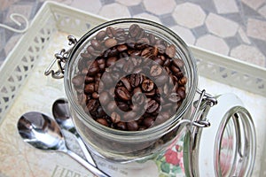 Background with many small coffee beans in the jar photo