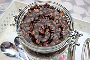 Background with many small coffee beans in the jar photo