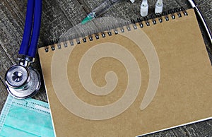 Background for medical subjects with copy space for text: View on empty blank brown cover of ringe file book with, stethoscope, photo