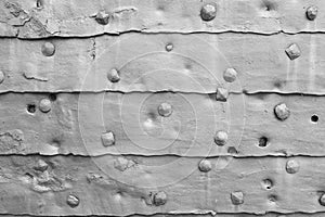 Background of metal surface from sheets with rivets, close-up. Texture of the iron gate. A metal relief backing for