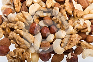 background of mixed nuts -  hazelnuts, walnuts, cashews,  pine nuts.