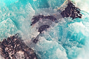 Background of natural mineral. Turquoise crystal in a dark brown nugget
