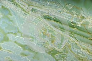 Background from natural polished Verde Onyx stone of green color with light streaks photo