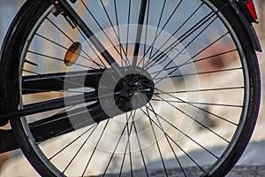 Background, an old bicycle wheel with the sea in the background, many now prefer to move by bike to go for a day at the beach