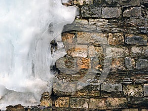 Background old brick wall with big icicle, texture. Vintage