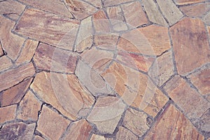 Background of old brown tiles made of irregular shaped stones