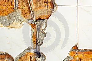 Background of old cracked red brick with the remains of unbroken tiles and the old wires