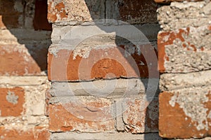 background of an old red brick wall. An unusual design made of bricks and cement of an old building. Cobwebs on the surface of an