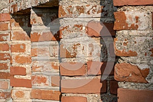 background of an old red brick wall. An unusual design made of bricks and cement of an old building. Cobwebs on the surface of an