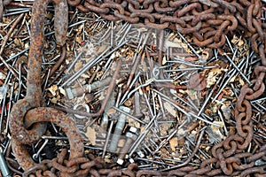 Background of old rusty bent nails, bolts, nuts, screws, chain