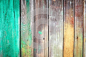 Background of old wooden boards with nails, green and yellow paint stains on textured wood plank.