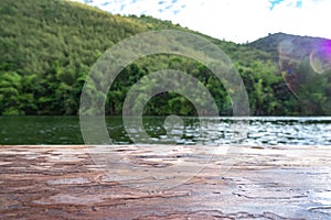 Background, old wooden table and view of the reservoir with mountain behind