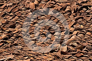 Background ornament terracotta red ancient tiles. Destructed riuined roof, India, Karnataka