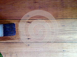 Background paintbrush staining pine floorboards before after