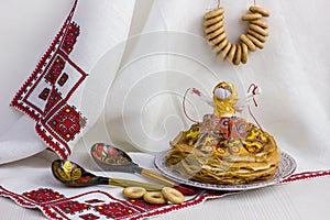 Background with pancakes, textile doll, wooden spoon, rushnik and sushki for Maslenitsa festival.