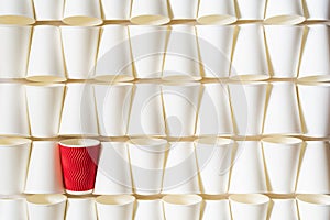 Background pattern of white paper cups with red cup in the middle