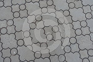 Background - pavement of curved grey interlocking concrete tiles