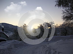 Background photo of low clouds in a mountain valley, vibrant blue and orange sky. Sunrise or sunset view of mountains and peaks
