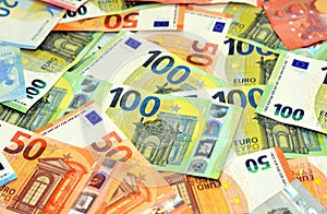 A background of a pile of different euro bill banknotes of 100 one hundred euros bill, 50 fifty euro bills and 20 twenty euros,