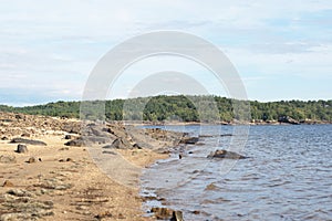 Cuerda del Pozo reservoir, shore full of rocks and water. photo