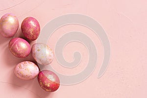 Background with pink Easter eggs with golden spots