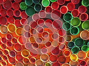 Background of plastic colorful bottle caps. Contamination with plastic waste. Environment and ecological balance. Art from junk. photo