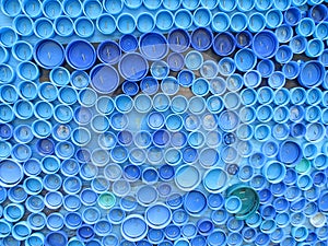 Background of plastic colorful bottle caps. Contamination with plastic waste. Environment and ecological balance. Art from junk.