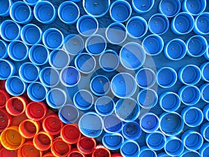 Background of plastic colorful bottle caps. Contamination with plastic waste. Environment and ecological balance. Art from junk. photo