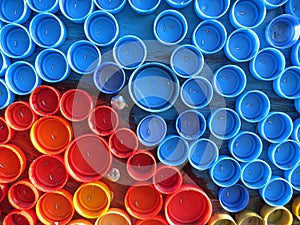 Background of plastic colorful bottle caps. Contamination with plastic waste. Environment and ecological balance. Art from junk. photo