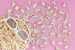 Background. Popcorn, cup and 3d glasses on a pastel pink background. Flat lay. Copyspace