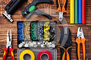 Background of professional electrician tools: cable lugs in the organizer box, insulating tape, earplugs, cutters, tips, burnerpul