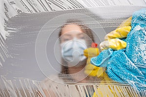 Background of purity, focusing on glass. The girl washes the mask actively, disinfecting everything from viruses, bacteria and