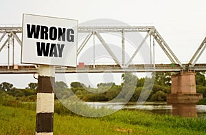 On the background of the railway bridge there is a sign with the inscription - Wrong Way