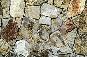 Background of raw natural stone, for the facade of the house in gray and brown shades