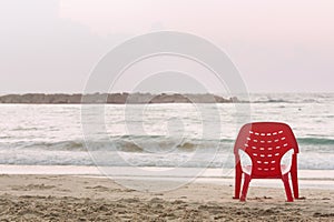 Background with red chair at the water`s edge