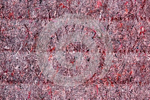 Background of red lining with fibers from non-uniform fabric. Texture of grey felt material