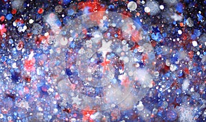 Red, white, and blue sparkling glitter scattered with shiny stars confetti. 4th of July celebration background