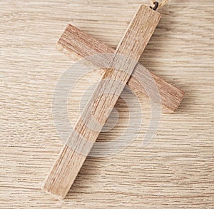 Background, religion and closeup of wooden cross on table for worship to God, prayer and resurrection of Jesus Christ