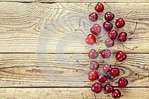 Background with ripe cherries on old wooden boards.