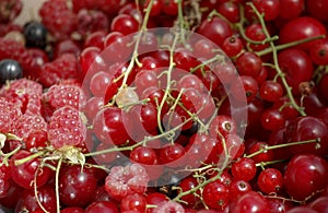 background of ripe juicy berries of red currants, raspberries and cherries. Close-up plan view from above