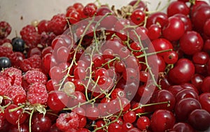 background of ripe juicy berries of red currants, raspberries and cherries. Close-up plan view from above