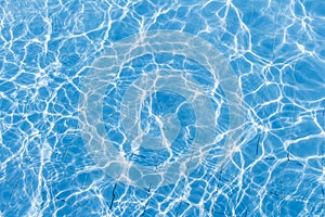 Background of rippled pattern of clean water in a blue swimming