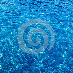 Background of rippled pattern of clean water in blue swimming po