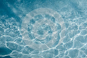 Background of rippled pattern of clean water in a blue swimming pool