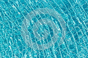 Background of rippled pattern of clean water in a blue swimming pool