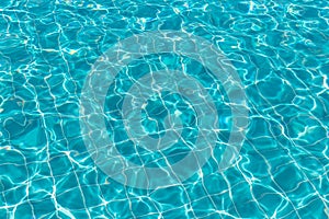 Background of rippled pattern of clean water in a blue swimming pool