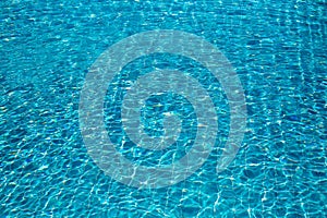 Background of rippled pattern of clean water in a blue swimming pool