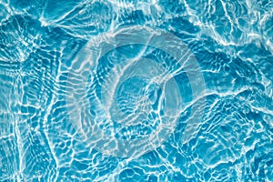 Background of rippled pattern of clean water in a blue swimming pool