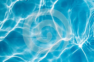 Background of rippled pattern of clean water in a blue swimming pool