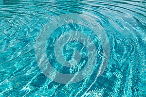 Background of rippled pattern of clean water in a blue swimming pool